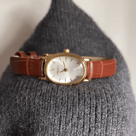 Montre minimaliste classique pour femme avec boîtier ovale en or et bracelet marron