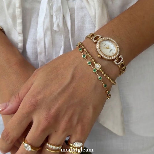 Luminous Chic Elegant: White Mother-of-Pearl Oval Dial Watch with Gold Diamond Bezel & Stainless Steel Bracelet.