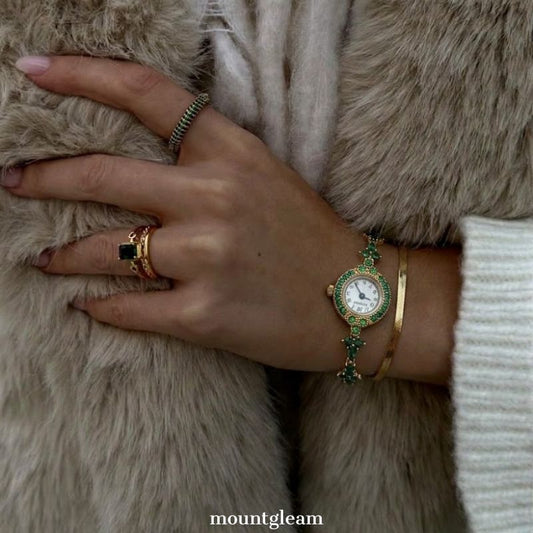 Emerald Luxe: Gold Round Dial Watch with Green Gemstone Bezel & Green Accent Bracelet