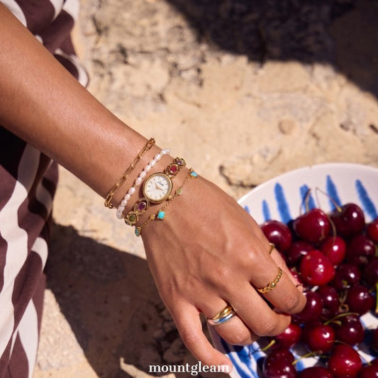 Oval Elegance: White Oval Dial Watch with Gold Bezel & Color Gemstone-Accented Gold Bracelet