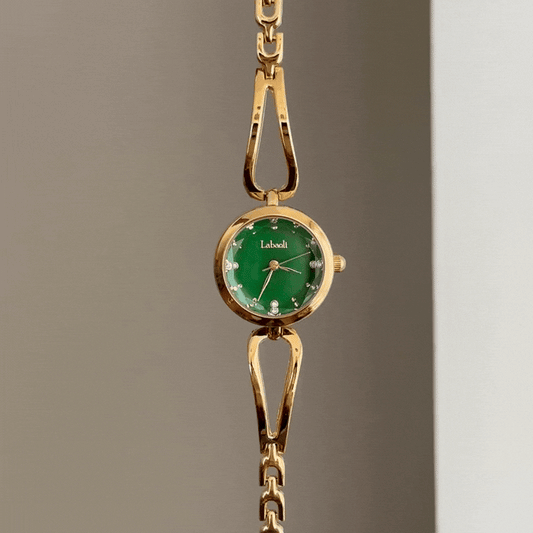 Vergoldete Eleganz: Grüne Armbanduhr mit rundem Zifferblatt, goldener Lünette und Armband