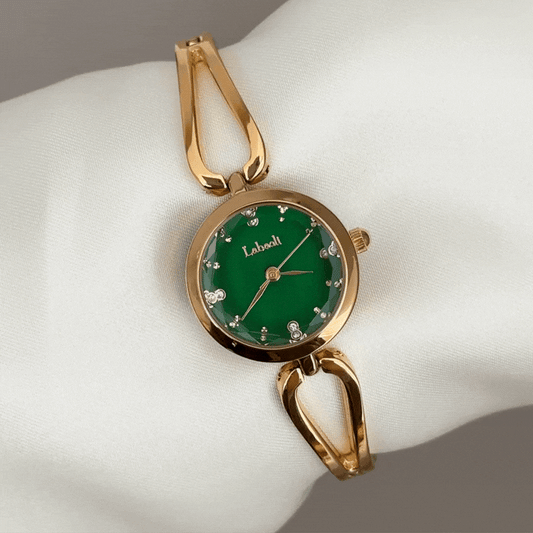 Vergoldete Eleganz: Grüne Armbanduhr mit rundem Zifferblatt, goldener Lünette und Armband