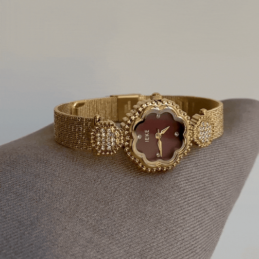 Romantischer Glamour: Uhr mit rotem, blumenförmigem Zifferblatt, goldener Blumenlünette und Armband