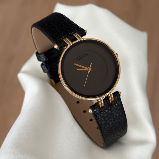 Timeless Contrast: Black Round Dial Watch with Gold Bezel & Black Leather Strap