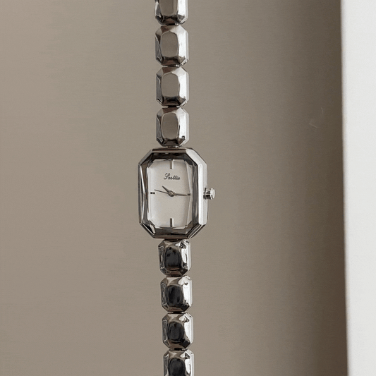 Geometrisch Elegant: Weiße, rechteckige Zifferblattuhr mit silbernem Gliederarmband mit eckigen Segmenten