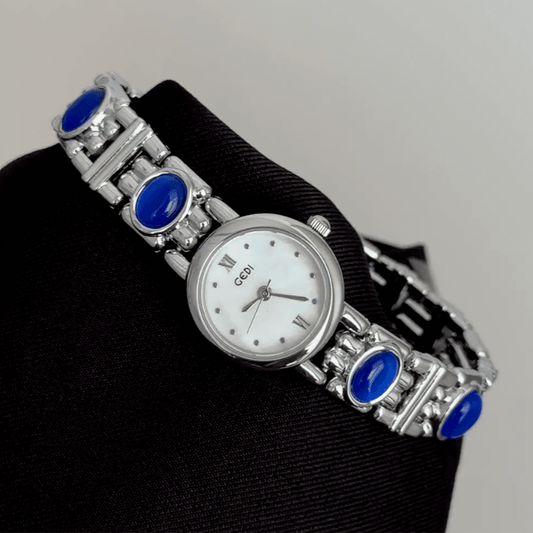 Chic Grace Elegant: White Mother-of-Pearl Round Dial Watch with Silver Bezel & Blue Gemstone Alloy Bracelet