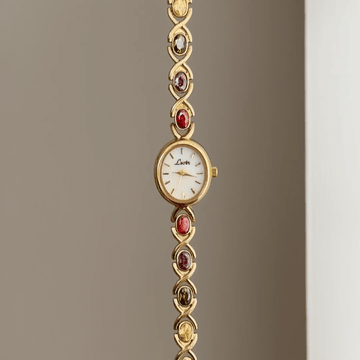 Oval Elegance: White Oval Dial Watch with Gold Bezel & Color Gemstone-Accented Gold Bracelet