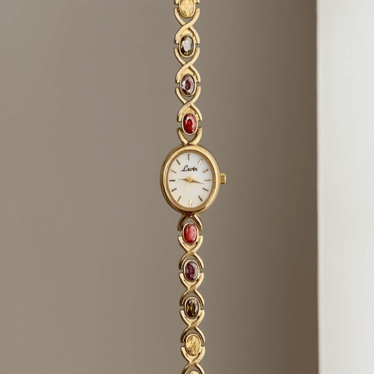 Oval Elegance: White Oval Dial Watch with Gold Bezel & Color Gemstone-Accented Gold Bracelet