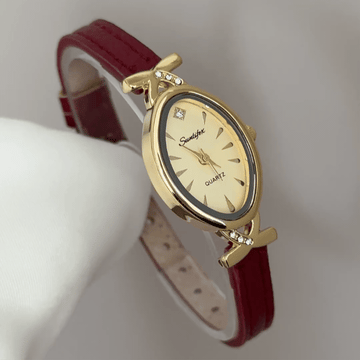 Chic Accent: Gold Oval Dial Watch with Matching Bezel & Red Leather Strap