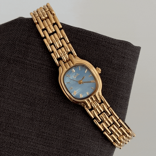 Modern Contrast: Blue Round Dial Watch with Gold Bezel & Gold Alloy Strap