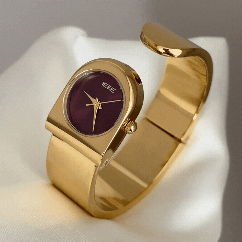 gold cuff watch with red round dial